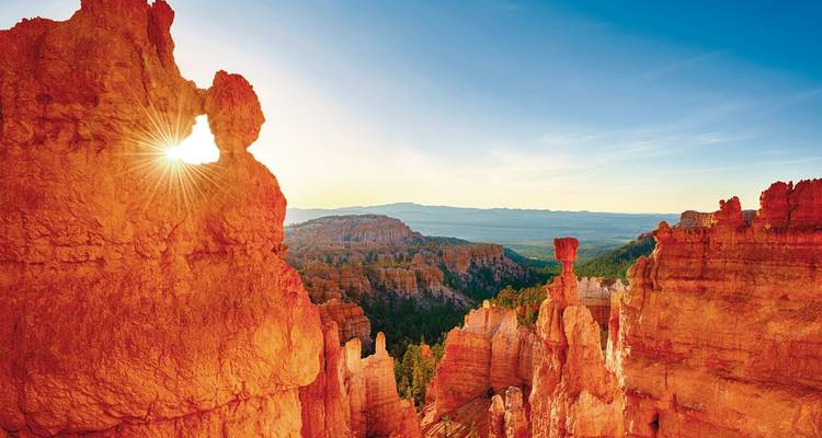 Strahlende Sonne scheint durch rote Hoodoos des Bryce Canyon bei Sonnenaufgang