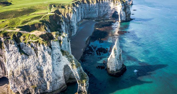 Les spectaculaires falaises blanches de craie et l'arche naturelle d'Étretat dominant les mers turquoise.