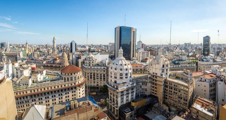 Panoramablick auf die Skyline von Buenos Aires mit klassischen Kuppelgebäuden und modernem Hochhaus, das sich über das dichte Stadtgefüge erhebt