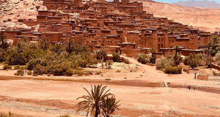 Village de terre ancien d'Ait Benhaddou entouré par un paysage désertique.