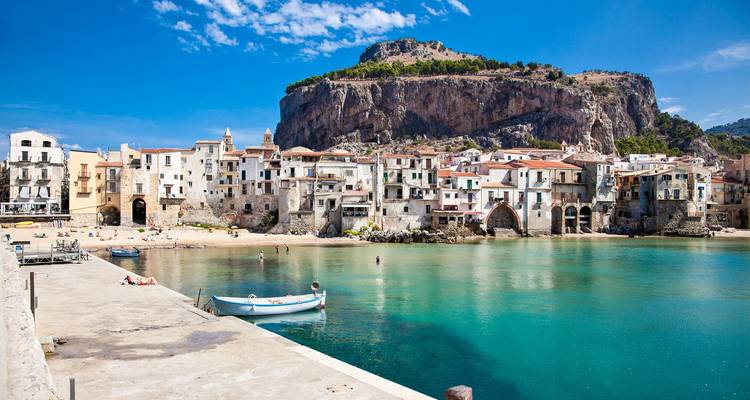 Kristalhelder baai en middeleeuws kustdorpje Cefalù met op de achtergrond een uitstekende rotsachtige vooruitstekende kaap.
