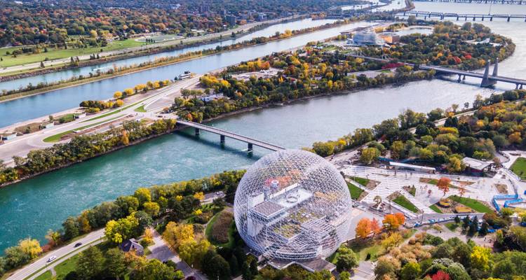 Luchtfoto van het najaar van Montreals Biosphere geodetische koepel naast de Sint-Laurensstroom en kleurig gebladerte.