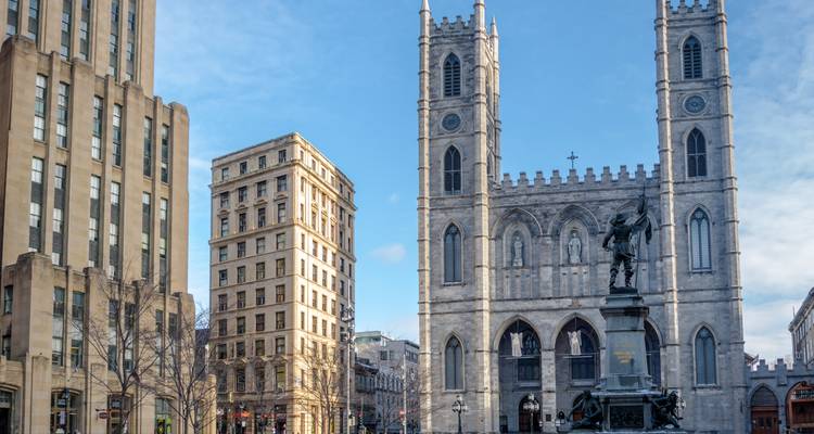 Die gotische Kathedrale Notre-Dame-Basilika ragt über den Place d'Armes Platz im Alten Montreal an einem klaren Tag auf.