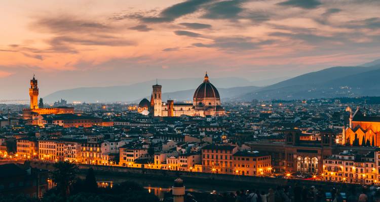 Twilight panorama van Florence met de kathedraal koepel en Palazzo Vecchio die gloeien tegen dramatische zonsondergang wolken.