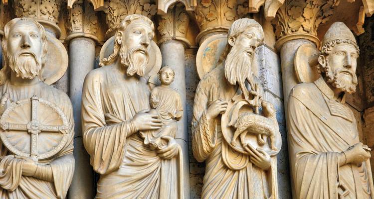 Primer plano de santos medievales tallados intricadamente y figuras bíblicas en la fachada de una catedral.