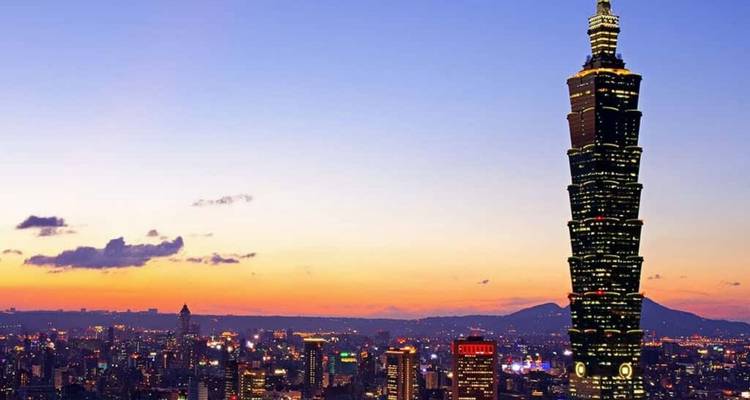 Taipeh-Skyline bei Sonnenuntergang, dominiert vom imposanten Taipei 101 vor einem farbenfrohen Himmel.