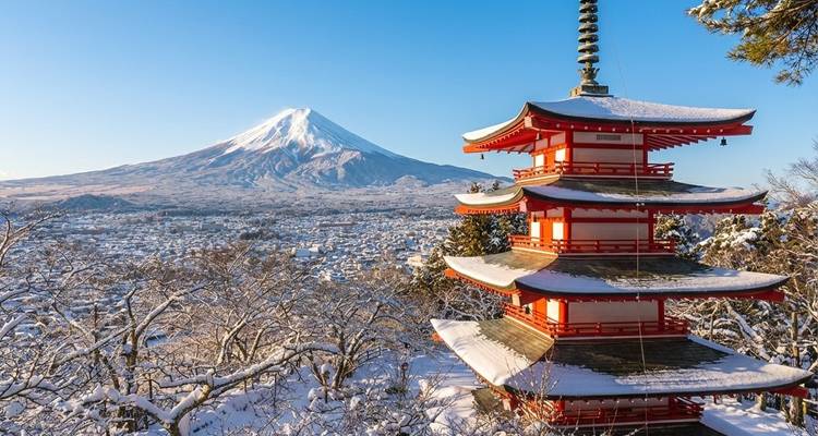 Mit Schnee bedeckte Chureito-Pagode, die den Fuji vor einem klaren Winterhimmel einrahmt.
