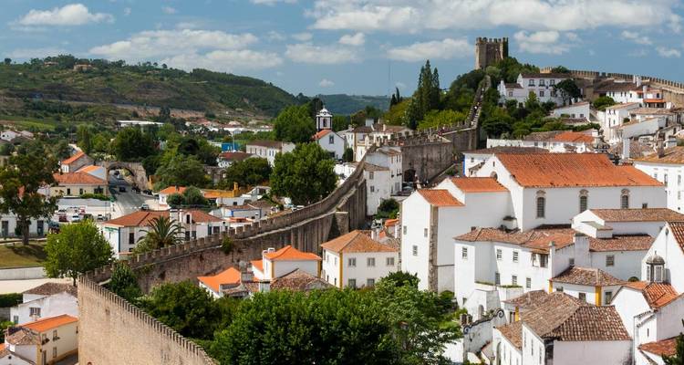 Pintoresco pueblo medieval de Óbidos con murallas y casitas blancas en lo alto de la colina