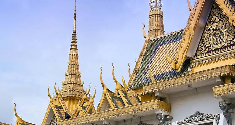 Dekorative goldene Dächer und Spitzen des Königspalastes von Phnom Penh vor einem hellen Himmel.