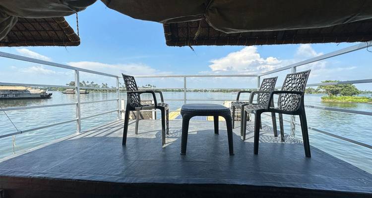 Hinteres Beobachtungsdeck eines Hausboots mit Kunststoffstühlen mit Blick auf die weitläufigen Backwater-Gewässer.