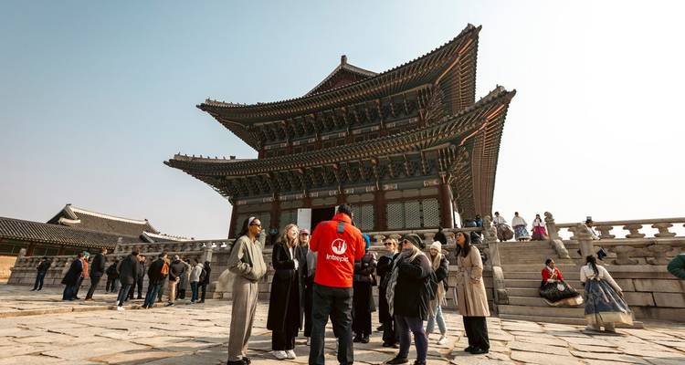 Le guide touristique s'adresse au groupe devant le hall principal orné du Palais de Gyeongbokgung.