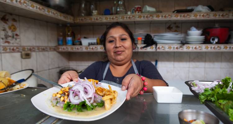 Marktkok presenteert een bord Peruaanse ceviche over een kleine eetskraam balie