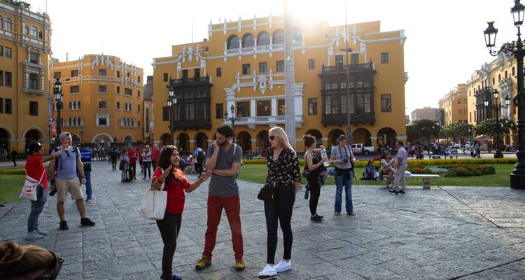 Soortgelijk uitzicht op het levendige Plaza de Armas met middagzonnegloed en bezoekers die met elkaar praten