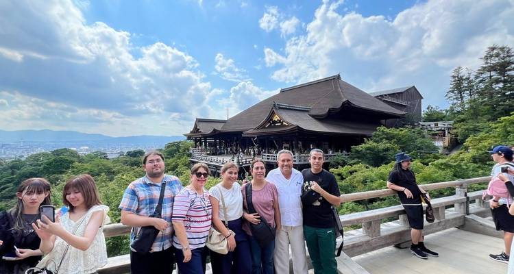 Reisegruppe, die auf der Terrasse des Kiyomizu-dera-Tempels mit Blick auf die Stadt Kyoto posiert.