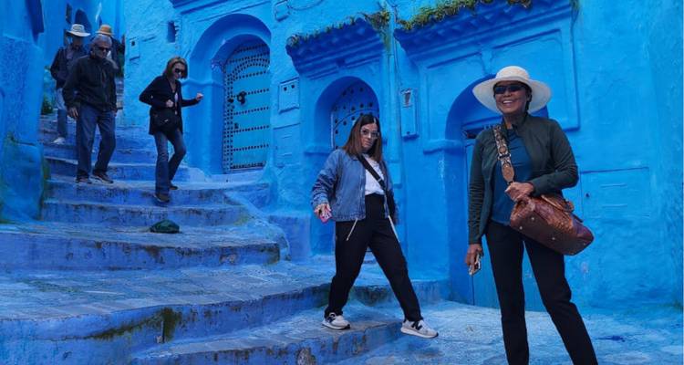 Les touristes descendent l'escalier bleu emblématique de la médina de Chefchaouen