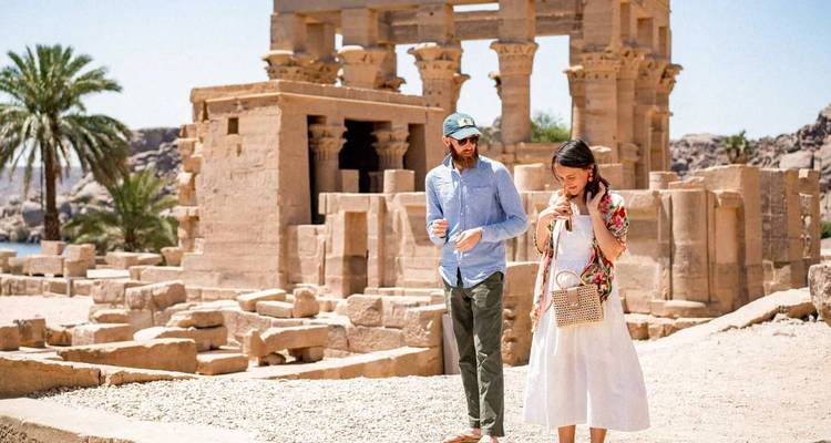 Una pareja explora las columnas de arenisca y las ruinas del Templo de Filas junto al Nilo.
