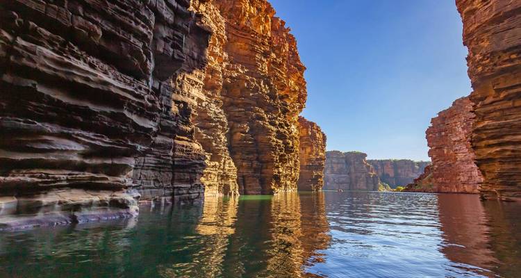 Las paredes de garganta de arenisca roja pura se desploman en aguas tranquilas y reflectantes en la región de Kimberley.