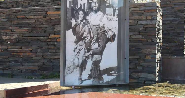 Exposition extérieure de la photographie iconique du soulèvement de Soweto de 1976 montée à côté d'un plan d'eau réfléchissant