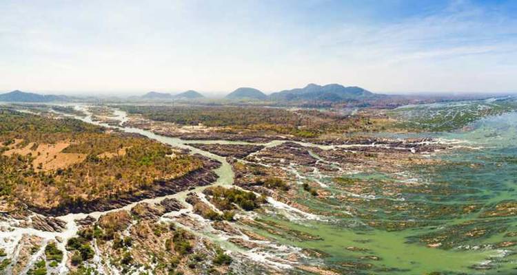 Panorama aéreo de rápidos extensos e islotes donde un río ancho se divide a través de un paisaje plano.