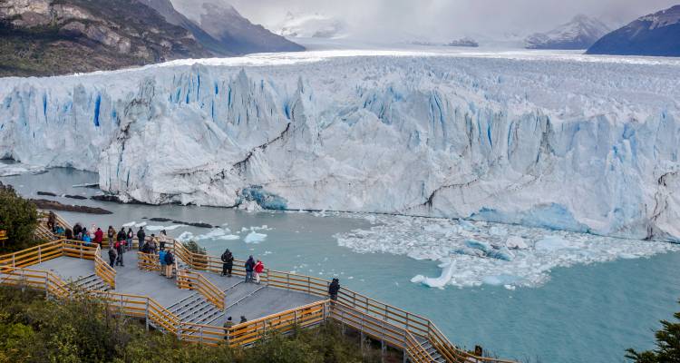 Bezoekers op houten uitkijkplatforms die genieten van het enorme gezicht van de Perito Moreno-gletsjer