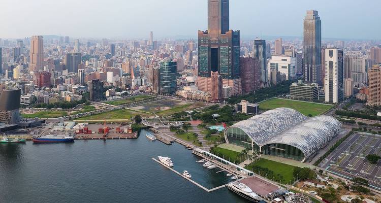 Luftaufnahme des Hafens von Kaohsiung mit moderner Skyline und Ausstellungszentrum.