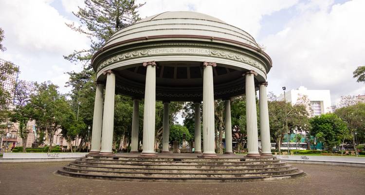Le pavillon en forme de dôme du Templo de la Música se dresse parmi les arbres d'un parc urbain sous un ciel nuageux.