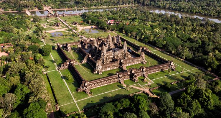 Bird’s-eye view of Angkor Wat complex surrounded by lush jungle and ancient moats.