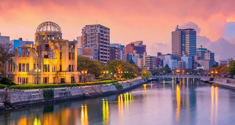 Atoomkoepel en moderne Hiroshima skyline weerspiegeld in de rivier bij kleurrijke schemering