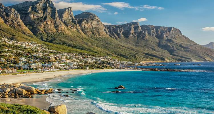 Camps Bay’s white sands beneath the rugged Twelve Apostles mountains, turquoise Atlantic waters sparkling.