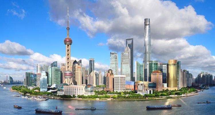 Panoramischer Tagesblick auf Shanghais Pudong-Skyline mit dem Oriental Pearl Tower und dem Shanghai Tower, die sich über dem Huangpu-Fluss erheben.