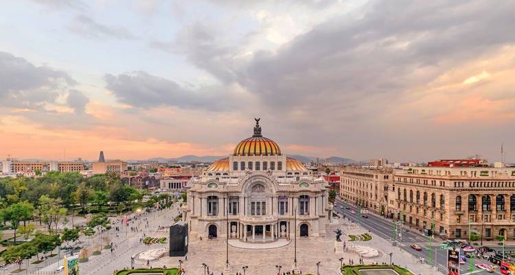 Luftaufnahme der Skyline von Mexiko-Stadt mit der Kuppel des Palacio de Bellas Artes bei Sonnenuntergang.