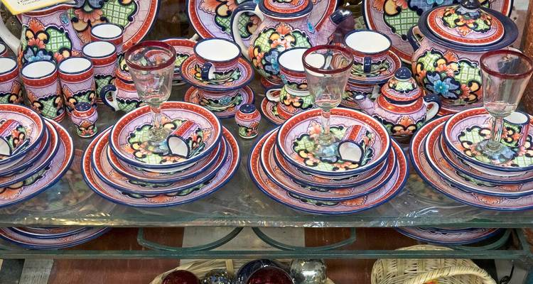 Ausstellung von aufwendig bemaltem Talavera-Geschirr auf Regalen in einem Marktladen.