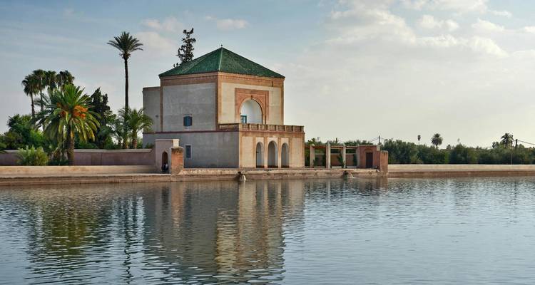 Pavillon Menara serein reflété dans son grand bassin d'eau entouré de palmiers à Marrakech.