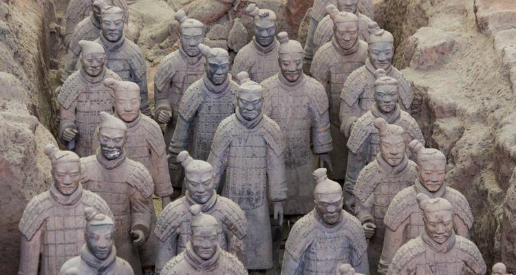 Close-up view of rows of life-size Terracotta Warriors standing in excavation pits.