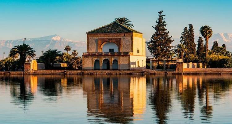 Le pavillon de la Menara se reflétait parfaitement dans un bassin tranquille avec l'Atlas en arrière-plan.