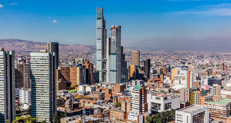 Panoramisch stadslandschap van Bogotá met moderne wolkenkrabbers die uitsteken boven het uitgestrekte stedelijke landschap en de Andes op de achtergrond.