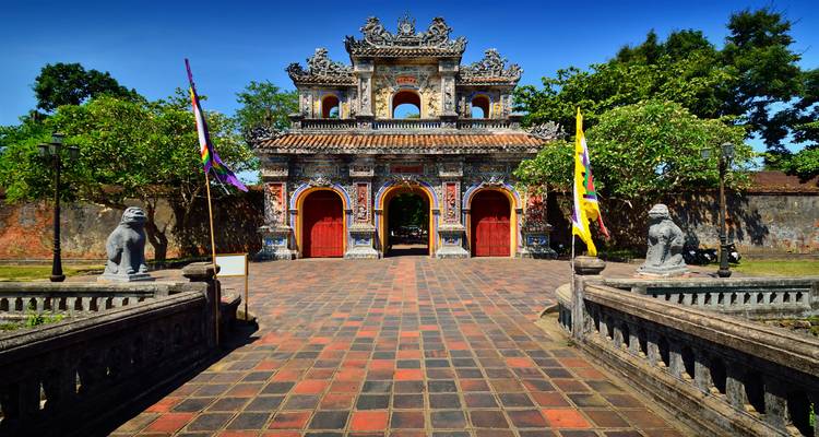 Colorida antigua puerta de la Ciudadela Imperial en Hue bajo un vibrante cielo azul.