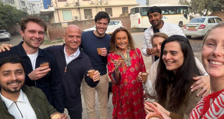 Gelukkige reizigers delen traditionele chai in kleine kleibekers op een drukke Indiase straat.