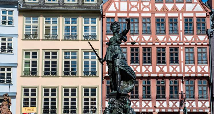 Statue de la Justice devant des maisons à colombages colorées sur la place du Römerberg à Francfort.