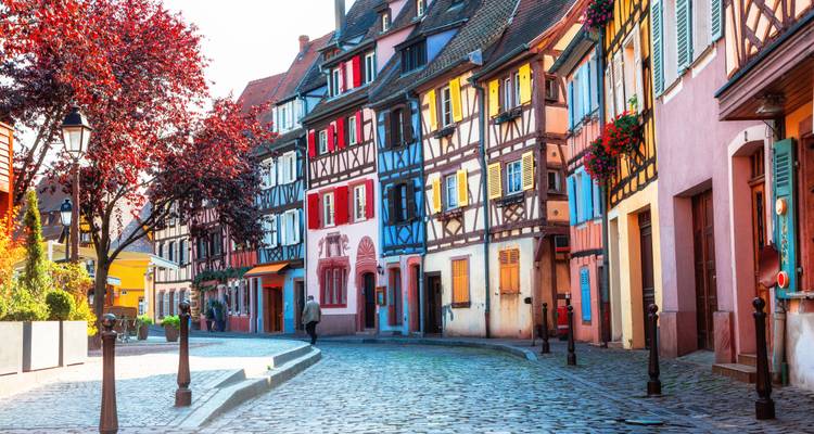 Charmante Kopfsteinpflasterstraße mit farbenfrohen Fachwerkhäusern in Colmar an einem sonnigen Tag