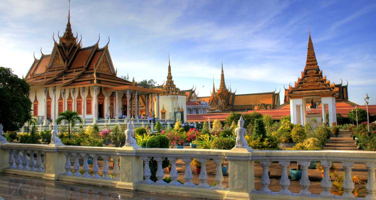 Royal Palace courtyard with traditional Khmer buildings and lush garden in warm morning light