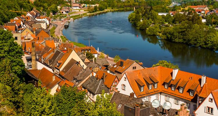 Huizen met oranje daken langs de riverbocht in het schilderachtige stadje Miltenberg, Duitsland.