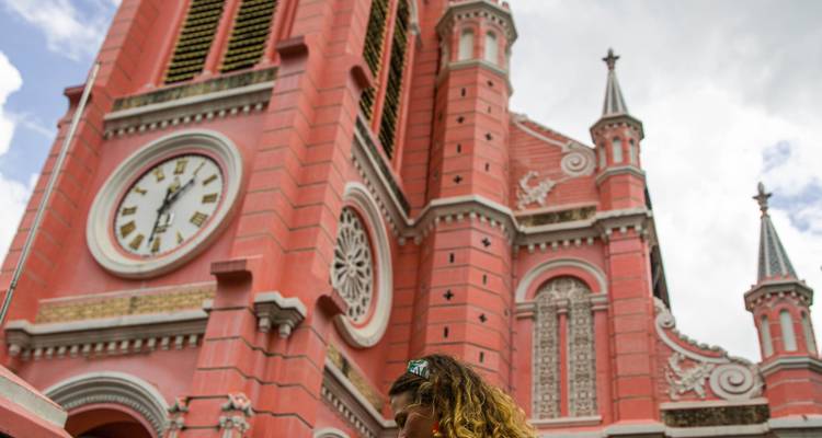 Viajero parado cerca de la fachada rosa vibrante y el reloj de la Iglesia Tan Dinh en la Ciudad de Ho Chi Minh.