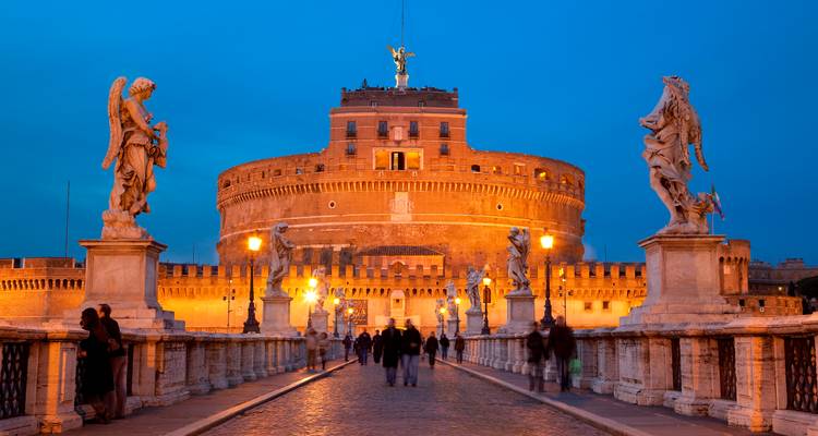 Scène du soir sur le Ponte Sant'Angelo menant au Castel Sant'Angelo, baignée dans une lumière chaleureuse contre un ciel bleu profond.