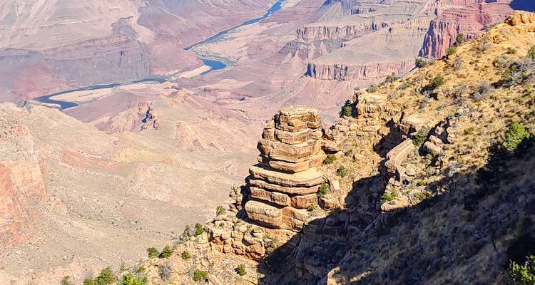Formaciones de rocas en capas y el sinuoso río Colorado vistos desde lo alto en el Gran Cañón.