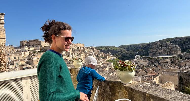 Vrouw en kind genieten van het panoramische uitzicht over het oude stenen stadsgezicht van Matera vanaf een hoog terras