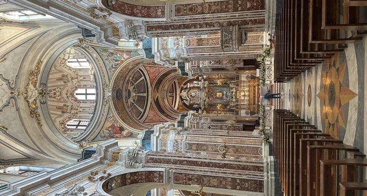 Prachtige barokke kerkinterieur met imposante bogen, sierlijke fresco's en een vergulde altaar