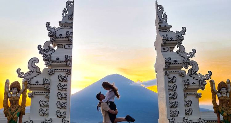 Romantisch stel ingelijst tussen sierlijke Lempuyang tempelpoorten met de Mount Agung bij zonsopgang.