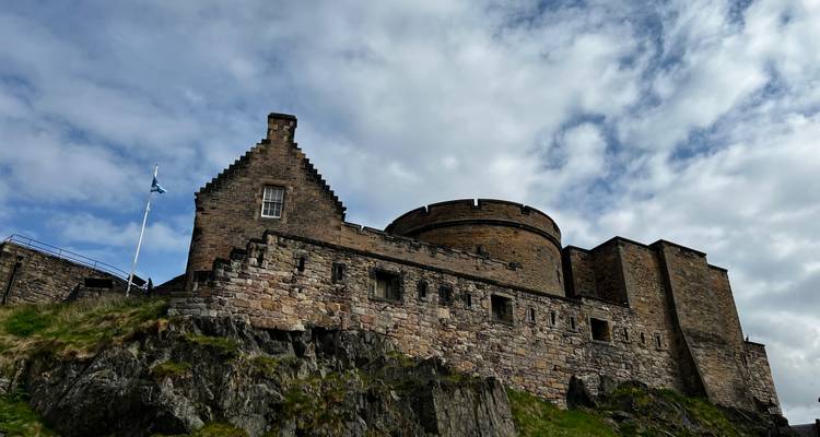 Les créneaux en pierre d'un château médiéval s'élevant contre un ciel partiellement nuageux