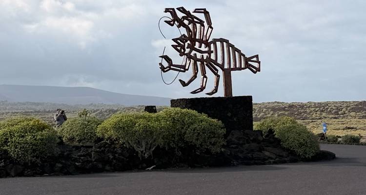 Sculpture de homard en métal sur un socle en pierre volcanique au milieu d'un paysage de lave à Lanzarote